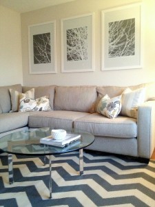 interior-sweet-white-wooden-frames-artwork-portray-at-white-wall-painted-over-cool-l-shaped-grey-fabric-sectional-sofas-with-cute-white-cushions-as-well-as-smart-round-glass-coffee-table-over-chic-che